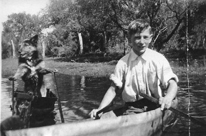Gerald Gugiatti with his dog in a boat on a flooded Odin Road