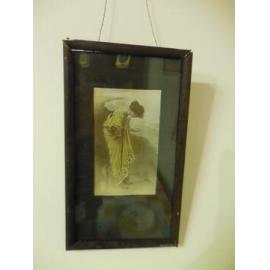 Wooden framed picture of woman collecting shells by the ocean