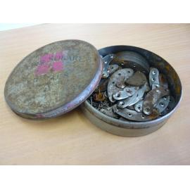 Round tin containing various shoe sole, heel tacks and stays