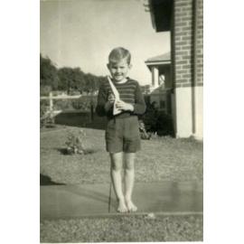Young boy with paper plane in hand at his house on Green Street in Joondanna