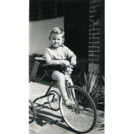 Young boy riding a bike in front of family home located on Green Street in Joondanna in 1953