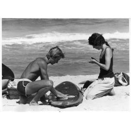Surfer waxing board at Scarborough Beach