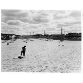 Surfer standing by board at Scarborough Beach 