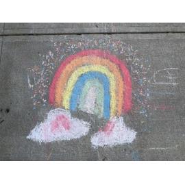Chalk drawing of a rainbow on a footpath