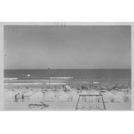 Scarborough beach with white beach tents and a set of swings