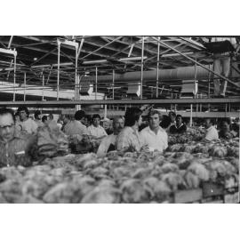 Interior view of Perth Markets with people looking at produce