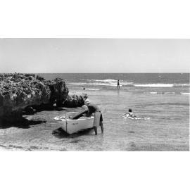 Man with dinghy at North Beach