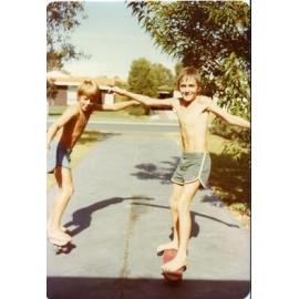 Kyle and Peter skating down a street in Trigg in c1978