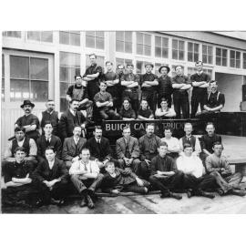 Group photograph of people around a sign which reads "Buick Cars & Trucks"