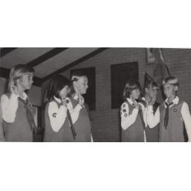 Girl Guides salute during award ceremony Wembley Downs Scout Hall c1975