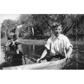 Gerald Gugiatti with his dog in a boat on a flooded Odin Road