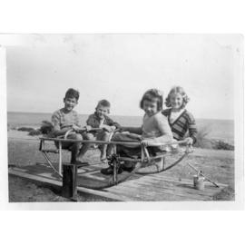 Children enjoying the play equipment on the grassed area, Watermans Bay C1950